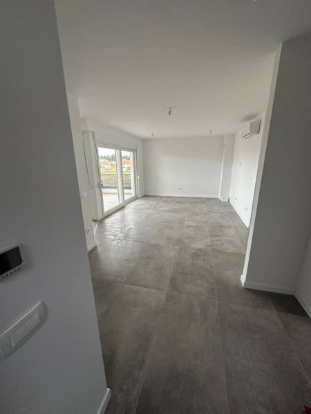 CHORVÁTSKO - Nové apartmány v pokojnej lokalite - SABUNIKE, Nin - Obývacia izba v 3-izbovom byte s terasou a šedou dlažbou.