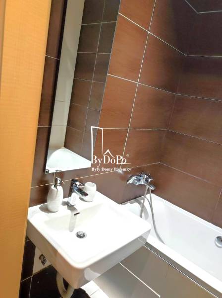 2-izbový byt, 49 m2, Cabanova ul., Bratislava - Dúbravka - Kúpeľňa s bielym umývadlom a vaňou, hnedé obklady, na ulici Cabanova.