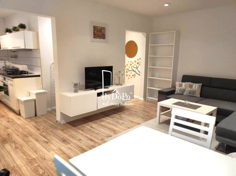 2-izbový byt, 49 m2, Cabanova ul., Bratislava - Dúbravka - Obývacia izba 2-izbového bytu na ulici Cabanova s kuchyňou a nábytkom.