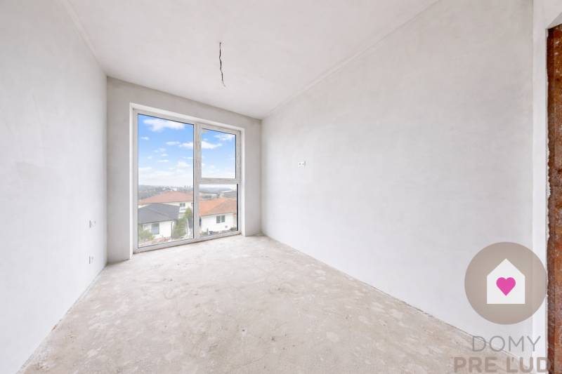 3i. BYT S VLASTNÝM TEP. ČERPADLOM + KLIMATIZÁCIA A EXTERIÉROVÉ ŽALÚZIE - Nezariadená izba v 3-izbovom byte s veľkým oknom a výhľadom na strechy.