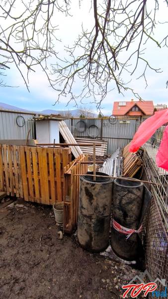Pekný stavebný pozemok v obci Krásnohorské Podhradie - Pozemky - bývanie na Mierovej ulici v Krásnohorskom Podhradí s materiálmi a sudmi.