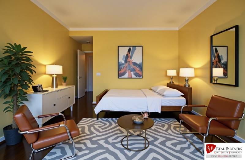 Predaj 3 izbový byt, 86 m2, Francisciho ul, Staré mesto, BAI . - Žlté steny, posteľ, kreslá a rastlina v 3-izbovom byte s podlahou s dreveným dekorom.