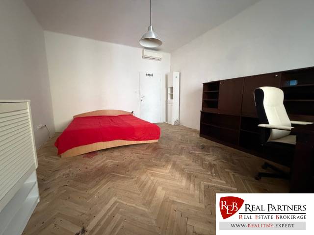 Predaj 3 izbový byt, 86 m2, Francisciho ul, Staré mesto, BAI . - Izba s posteľou, písacím stolom a podlahou s dreveným dekorom v 3-izbovom byte.