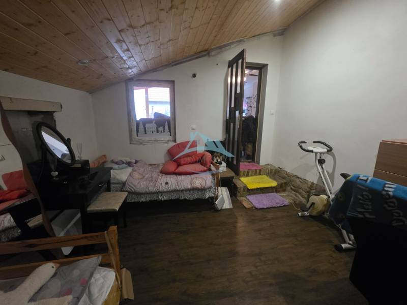 Útulný rodinný dom v tichej obci Hont, Maďarsko - Jedna izba v rodinnom dome s cvičebným bicyklom a podlahou s dreveným dekorom.