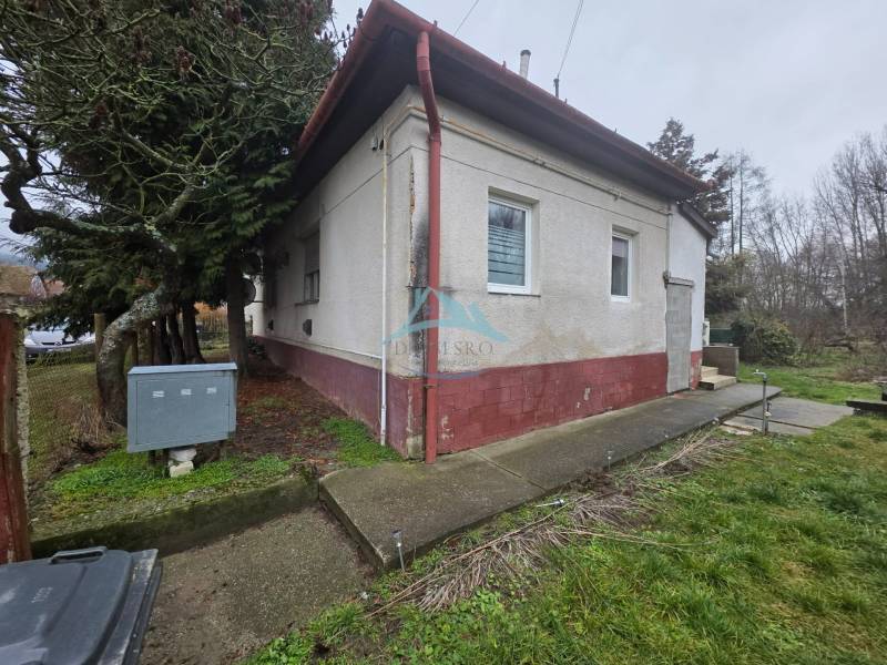 Útulný rodinný dom v tichej obci Hont, Maďarsko - Rodinný dom v Hont má bielu fasádu, okná s mrežami a vstupné schody.