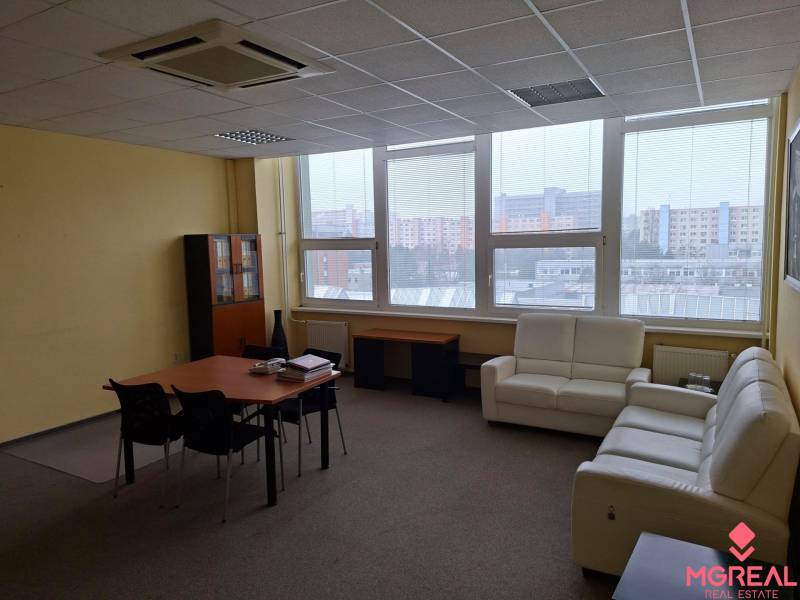 TOP CENA: Administratíva 420m2, Dúbravka - Priestranná kancelária s pohovkami, stolom a oknami s výhľadom na mestskú panorámu.