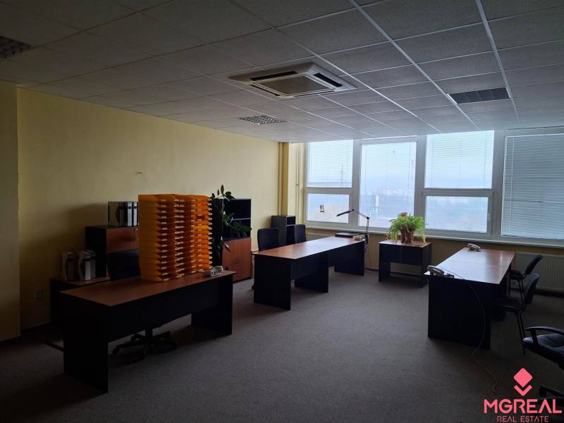 TOP CENA: Administratíva 420m2, Dúbravka - Interiér kancelárie s tromi písacími stolmi, rastlinami a výhľadom cez veľké okná.
