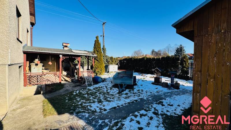 Na predaj 3 i RD v Partizánskom – Veľké Bielice, pozemok 1149 m2 - Záhrada rodinného domu vo Veľkých Bieliciach, Partizánske s prístreškom a zasneženým trávnikom.