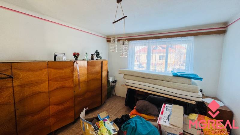 Na predaj 3 i RD v Partizánskom – Veľké Bielice, pozemok 1149 m2 - Izba v rodinnom dome s dreveným nábytkom, luster a okno s výhľadom.