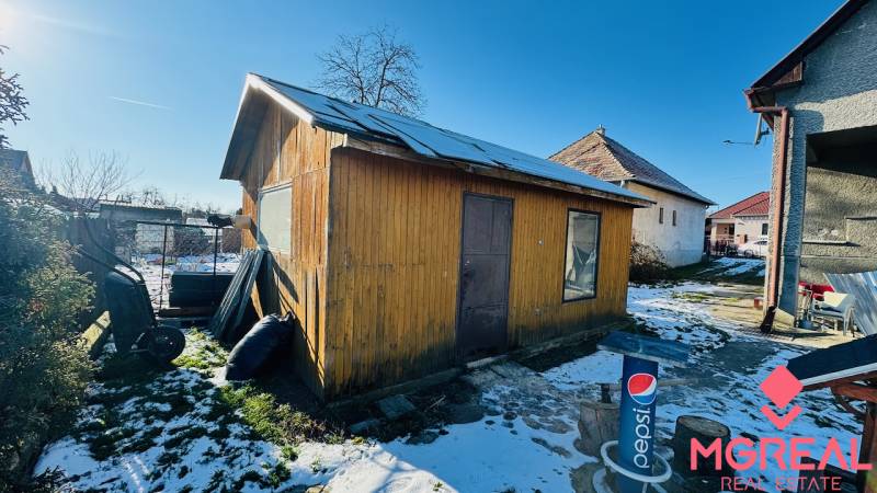 Na predaj 3 i RD v Partizánskom – Veľké Bielice, pozemok 1149 m2 - Za domom v Partizánskom, Veľkých Bieliciach, stojí drevená chatka na zasneženom dvore.