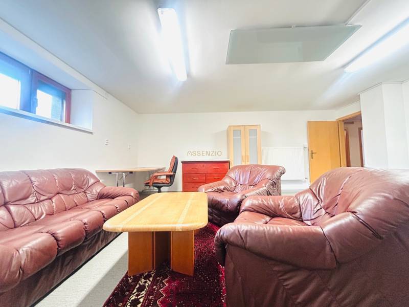 PRENÁJOM- KANCELÁRSKÝ PRIESTOR -120m2- KOMÁROVSKÁ - Kožená sedacia súprava s konferenčným stolíkom, koberec a pracovný kút v Rodinnom dome.