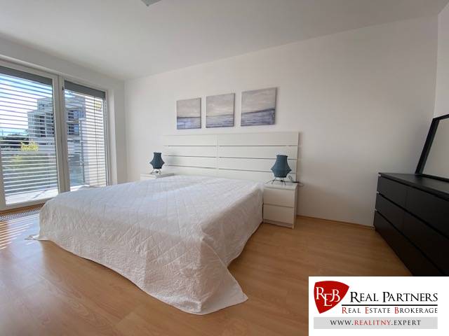 Prenájom 2 izbový 78 m2 + 30 m2 terasa,novostavba Koliba,zariadený - Svetlá spálňa v 2-izbovom byte s podlahou s dreveným dekorom a posuvnými dverami.