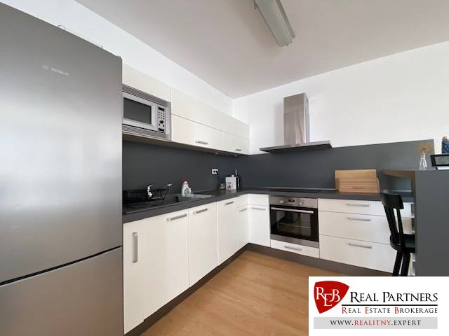 Prenájom 2 izbový 78 m2 + 30 m2 terasa,novostavba Koliba,zariadený - Kuchyňa v 2-izbovom byte s podlahou s dreveným dekorom, biele skrinky, nerezové spotrebiče.