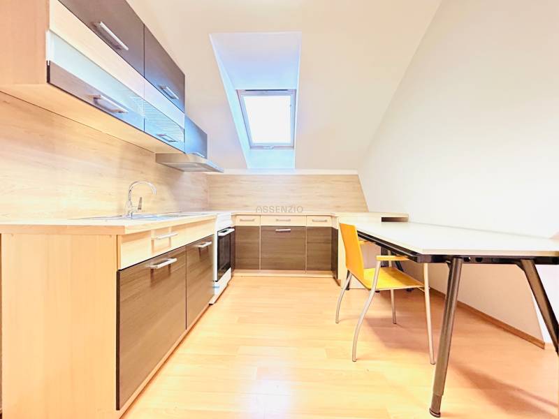 KANCELÁRSKE PRIESTORY- 120m2- KOMÁROVSKÁ - Kancelárie s kuchyňou a jedálenským stolom, svetlá podlaha s dreveným dekorom.