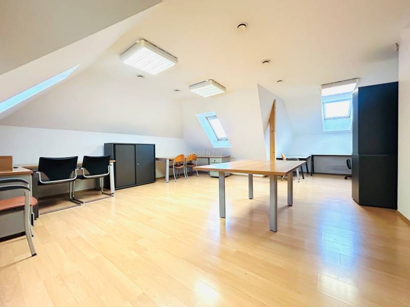 KANCELÁRSKE PRIESTORY- 120m2- KOMÁROVSKÁ - Podkrovné kancelárie s podlahou s dreveným dekorom, strešnými oknami a kancelárskym zariadením.