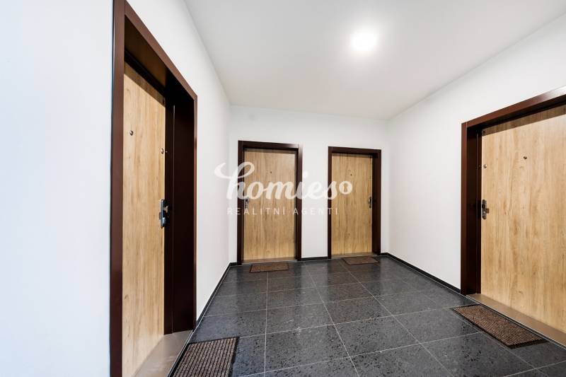 PRENÁJOM 3 izbový luxusný byt  v centre Nitry s veľkou terasou - Chodba s tromi vchodovými dverami a tmavou podlahou s dekoratívnymi prvkami.