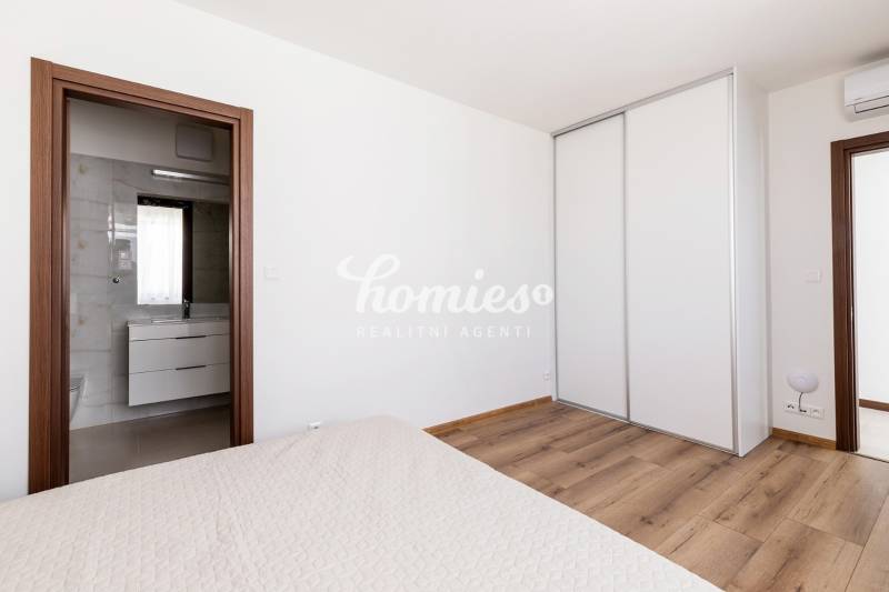 PRENÁJOM 3 izbový luxusný byt  v centre Nitry s veľkou terasou - Spálňa v 3-izbovom byte s podlahou s dreveným dekorom a vstavanou skriňou.