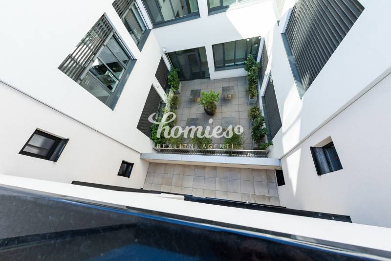 PRENÁJOM 3 izbový luxusný byt  v centre Nitry s veľkou terasou - Vnútorný dvor bytového komplexu v Nitre s terasovou dlažbou a zeleňou.