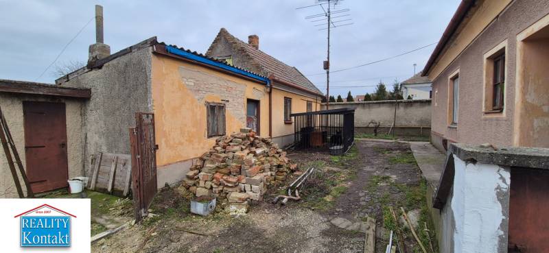 Na predaj 2 izbový rodinný dom s pozemkom - Dvory nad Žitavou - Rodinný dom v Dvoroch nad Žitavou s hromadou tehál a starou fasádou.