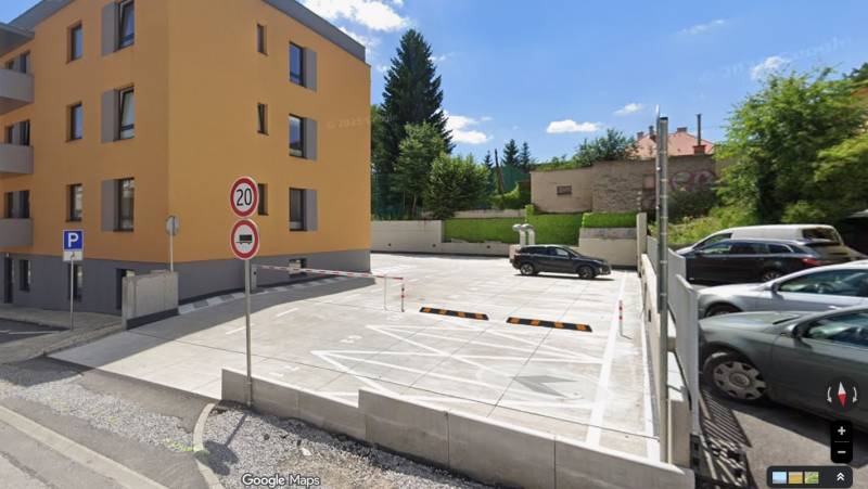 Parkovacie miesto v centre na predaj - Parkovisko a obytná budova na Rudlovskej ceste v Banskej Bystrici obklopené zeleňou.