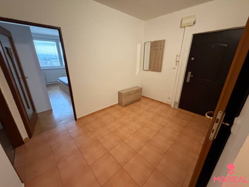 2 izbový byt s balkónom Topoľčany  - Vstupná hala 3-izbového bytu s keramickou dlažbou, vešiakom a pohľadom na izbu.