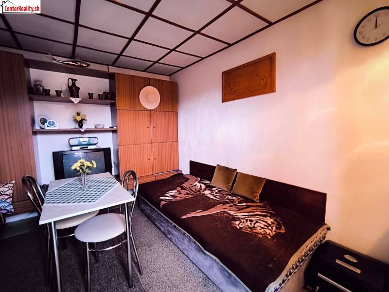 ‼️BRODZANY - ZÁHRADA S MUROVANOU CHATKOU NA PREDAJ, okr. PARTIZÁNSKE‼️ - Interiér chaty s pohovkou, jedálenským stolom a vstavanou skriňou, dominuje prírodná paleta farieb.