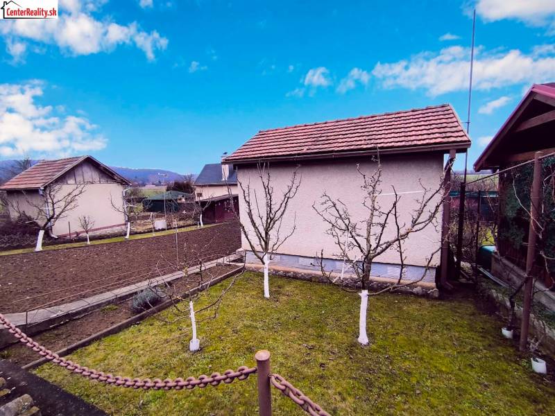 ‼️BRODZANY - ZÁHRADA S MUROVANOU CHATKOU NA PREDAJ, okr. PARTIZÁNSKE‼️ - Záhrada s chatou v Partizánskom, ovocné stromy a obrábaná pôda, jasná obloha.