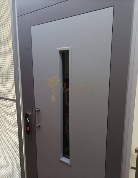 1-izb. byt, Pezinok - Sever, ul. Suvorovova - Šedé dvere so skleneným priezorom a tlačidlom výťahu, foto v 1-izbovom byte.