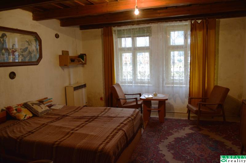 CHalúpka, na rekonštrukciu za cenu pozemku, dom Abrahám! - Izba v rodinnom dome s posteľou, kreslami, žltými závesmi a kobercom.