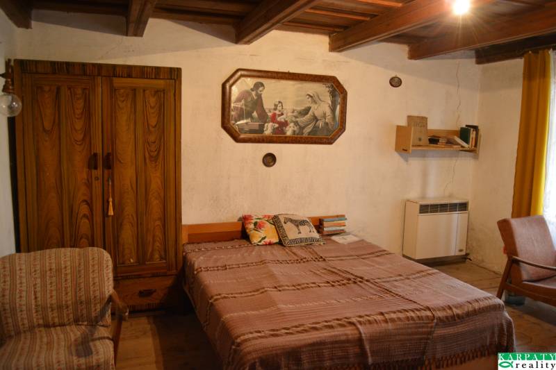 CHalúpka, na rekonštrukciu za cenu pozemku, dom Abrahám! - Spálňa v rodinnom dome s drevenou skriňou, posteľou a obrazom na stene.