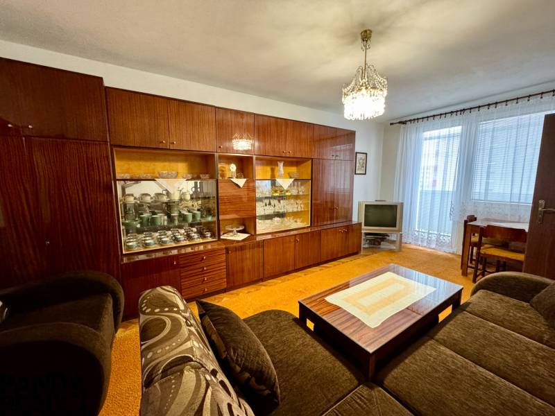 Na prenájom 3,5-izbový byt – Topoľčany, Sídlisko Východ - Obývacia izba s rustikálnou obývacou stenou a TV v 3-izbovom byte.