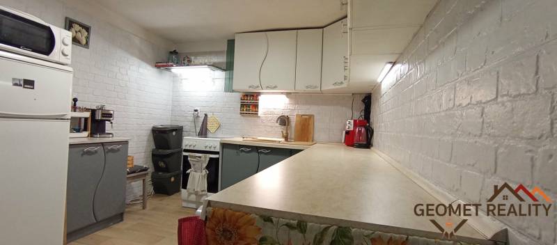 Útulný domček s dušou a moderným komfortom – Divín - Kuchyňa v rodinnom dome s bielymi tehlovými stenami a kuchynskými spotrebičmi.