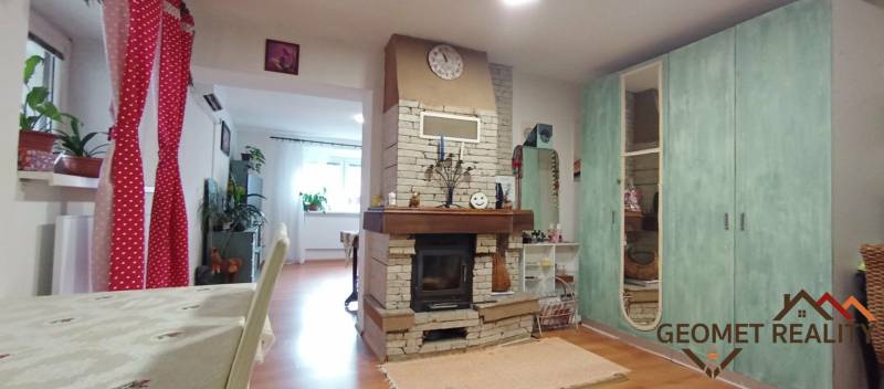 Útulný domček s dušou a moderným komfortom – Divín - Interiér rodinného domu s kozubom a podlahou s dreveným dekorom, kompletovaný pestrou výzdobou.