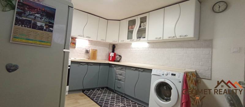 Útulný domček s dušou a moderným komfortom – Divín - Kuchyňa v Rodinnom dome s bielymi a šedými skrinkami, podlaha s dreveným dekorom.