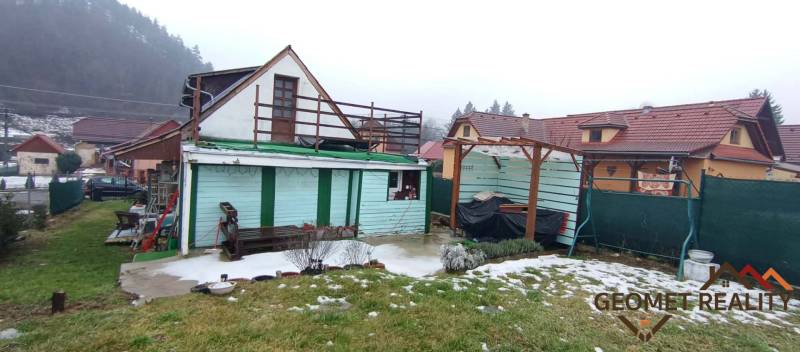 Útulný domček s dušou a moderným komfortom – Divín - Rodinný dom na Cintorínskej v Divíne s prístreškom na dvore a zasneženým trávnikom.