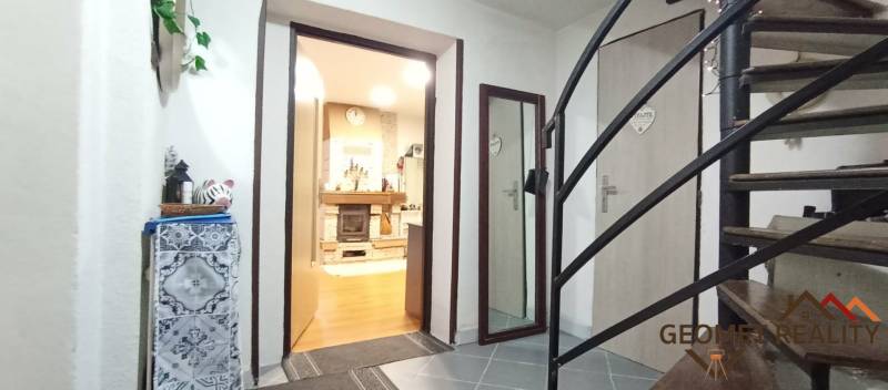 Útulný domček s dušou a moderným komfortom – Divín - Interiér rodinného domu so schodiskom, podlahou s dreveným dekorom a krbom.