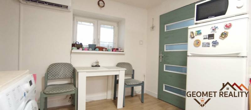 Útulný domček s dušou a moderným komfortom – Divín - Jedáleň v rodinnom dome s bielym stolom, chladničkou a podlahou s dreveným dekorom.