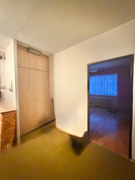 Predaj pôvodného 3+1 bytu v žiadanej lokalite v Čadci (MO) - Chodba so vstavanou skriňou v 3-izbovom byte, vstup do izby s podlahou s dreveným dekorom.