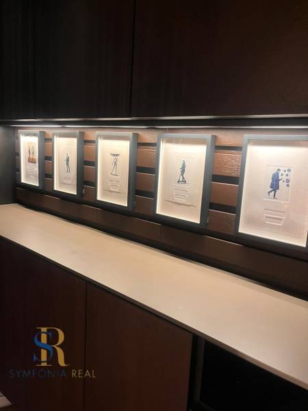 2-izbový byt v Pezinku s vlastným parkovaním - REZERVOVANÉ - Zarámované obrázky na drevenej policovej stene v 2-izbovom byte.