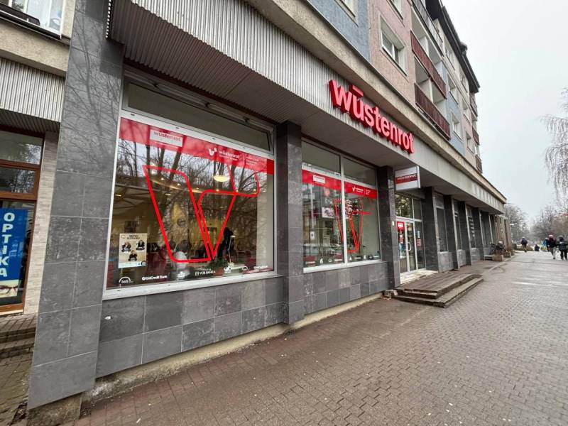 Exkluzívne - Obchodný priestor na prenájom v centre mesta Poprad - Obchodné priestory v Poprade s výrazným červeným logom na budove.