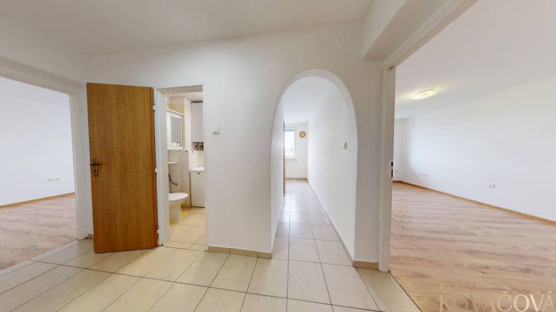 Na prenájom 2 izbový byt, Dežerice - Chodba v 2-izbovom byte s podlahou s dreveným dekorom a vstupom do kúpeľne.