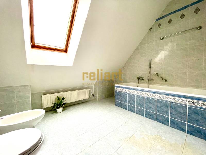 Záhorská Bystrica: Predaj domu kombinácia bývanie/podnikanie - Podkrovná kúpeľňa s rohovou vaňou a strešným oknom v rodinnom dome.