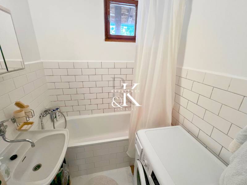 Predaj rekreačná chata s pozemkom, garážou a saunou Modra, Harmónia - Kúpeľňa v chate s vaňou, práčkou a bielym obkladom.