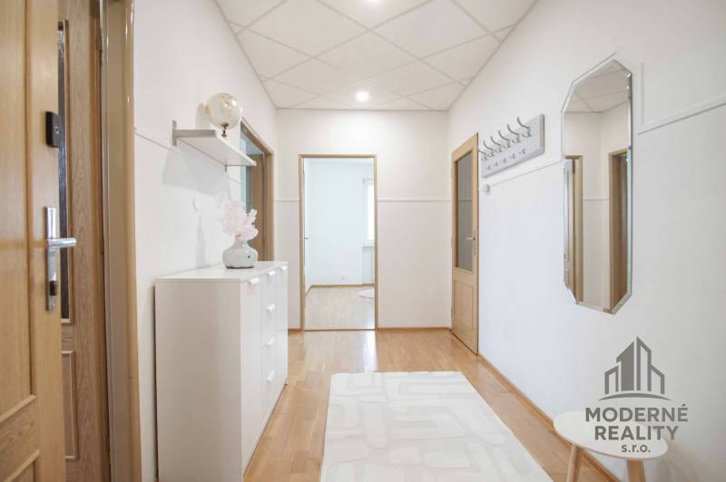 Na prenájom veľký 4-izbový byt s balkónom, garážou a záhradou, Kolta – - Chodba v 4-izbovom byte s podlahou s dreveným dekorom, jednoducho zariadená.