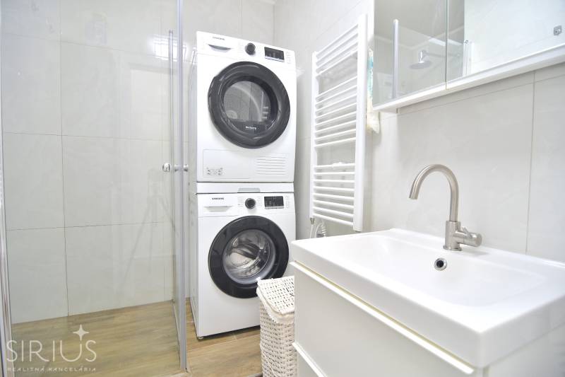 ŠTÚROVA, 3-i byt, 75 m2 – komplet rekonštrukcia, vlastné parkovanie - Kúpeľňa s práčkou a sušičkou v 3-izbovom byte s podlahou s dreveným dekorom.