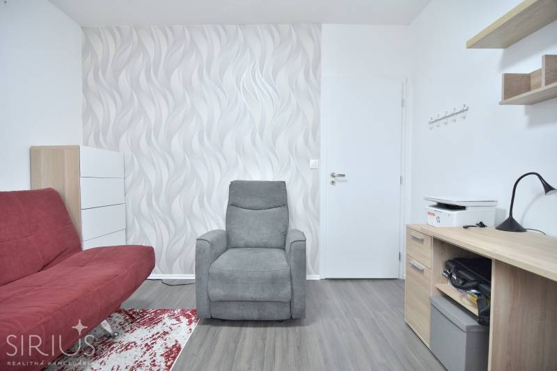 ŠTÚROVA, 3-i byt, 75 m2 – komplet rekonštrukcia, vlastné parkovanie - 3-izbový byt so sivým kreslom, červenou pohovkou a stolom s tlačiarňou.