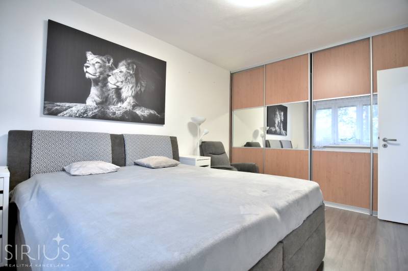 ŠTÚROVA, 3-i byt, 75 m2 – komplet rekonštrukcia, vlastné parkovanie - Spálňa v 3-izbovom byte so šatníkovou skriňou a čiernobielym obrazom levov.