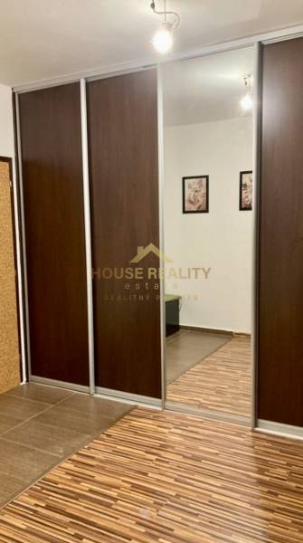 Prenájom 3 izbový byt, ulica Jána Poničana, BA IV. Devínska Nová Ves - Skriňa s posuvnými dverami a zrkadlom v 3-izbovom byte s podlahou s dreveným dekorom.