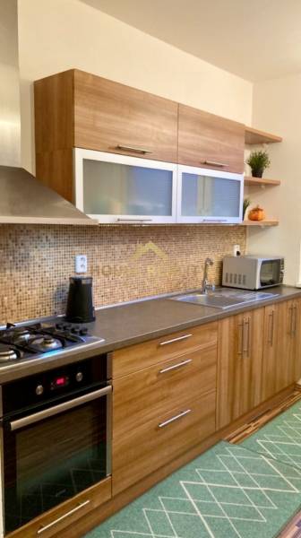 Prenájom 3 izbový byt, ulica Jána Poničana, BA IV. Devínska Nová Ves - Kuchyňa s dreveným dekorom a vstavanými spotrebičmi v 3-izbovom byte.