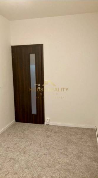 Prenájom 3 izbový byt, ulica Jána Poničana, BA IV. Devínska Nová Ves - Izba v 3-izbovom byte s kobercovou podlahou a tmavými dverami.